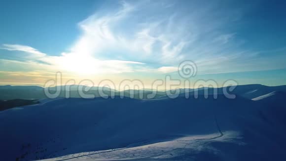 在被黄昏的太阳照亮的雪山上飞行视频的预览图