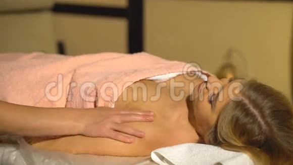 漂亮的金发女人在水疗中心做手按摩视频的预览图