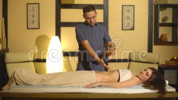 有油阿育吠陀水疗治疗的人背部和手部身体部分视频的预览图