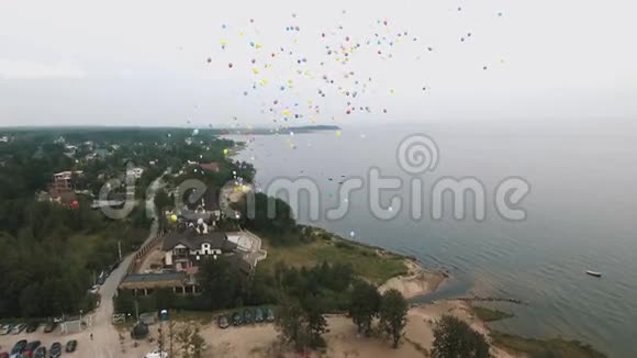 空中拍摄了许多五颜六色的气球飞上海面的天空视频的预览图