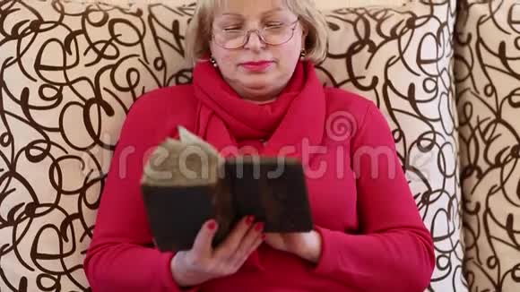坐在沙发上读旧书的女人视频的预览图