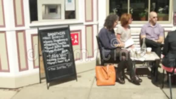 人们坐在人行道上的一家小咖啡馆外面3分之2视频的预览图