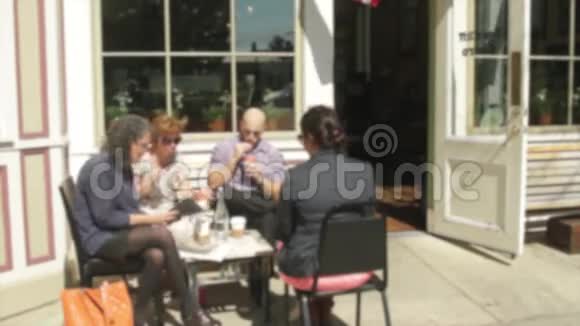 人们坐在人行道上的一家小咖啡馆外面3分之3视频的预览图