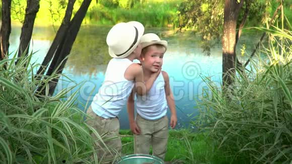 小兄弟钓完鱼后从湖岸上走孩子们休息后愉快地散步兄弟会视频的预览图