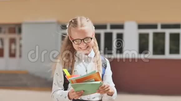 带背包和书的微笑学校女孩的肖像视频的预览图