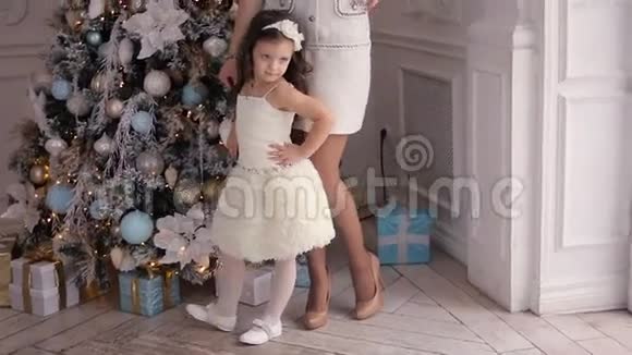 母亲和女儿站在圣诞树前三年视频的预览图