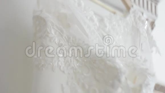 挂在架子上的婚纱特写镜头与交易模式和刺绣的织物连衣裙视频的预览图