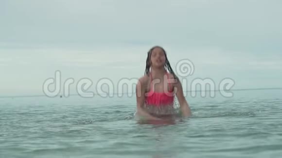 快乐快乐的年轻女孩在海上玩泼水慢动作股票录像视频的预览图