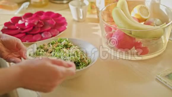 女人用手把沙拉和勺子混合在一起视频的预览图