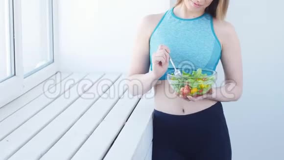 健康的饮食观念运动后吃健康沙拉的年轻女性视频的预览图