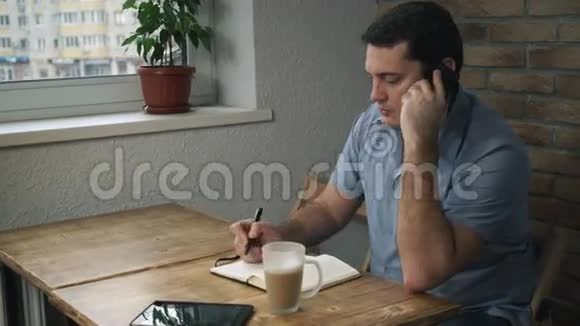 经理坐在咖啡馆里打电话在垫子上做笔记视频的预览图
