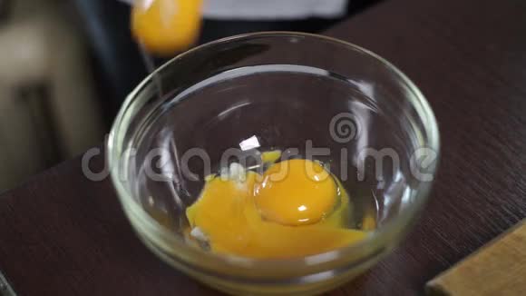 烘焙原料新鲜的有机鸡蛋落入深玻璃碗中混合视频的预览图