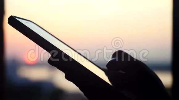在美丽的夕阳城市背景下女人手拿着手机3840x2160视频的预览图