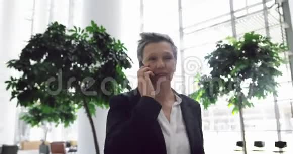 女商人在办公室4k大厅用手机说话视频的预览图