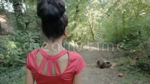 走在林间小路上的年轻女子视频的预览图