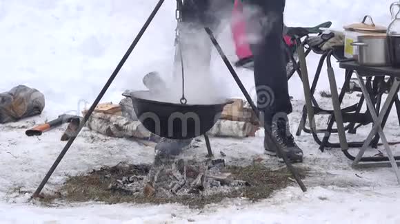 游客在冬天用锅做饭上面挂着篝火4K视频的预览图