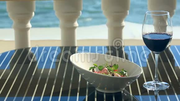 美食餐厅的一道菜特写镜头猪肉配蔬菜和一杯红酒海滨餐厅视频的预览图