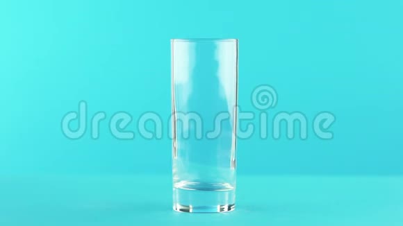 慢动作特写镜头果橙多果汁冷饮料喝成玻璃蓝色背景在视频的预览图