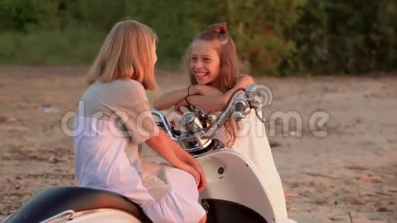 两个小女孩在水上海滩玩得很开心两个姐妹在海滩上享受天气两个女孩一起聊天视频的预览图