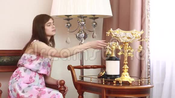 年轻漂亮的女人坐在椅子上打着老式电话视频的预览图
