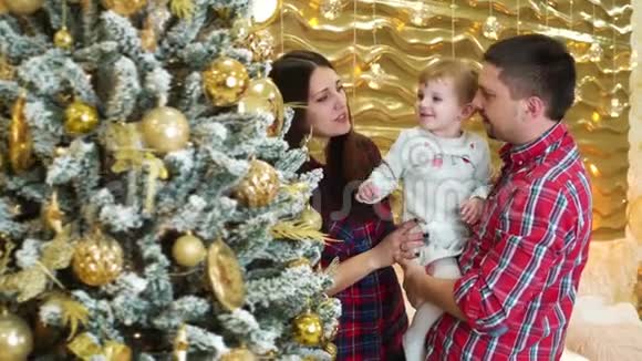 幸福的家庭和小女儿在家附近装饰圣诞树视频的预览图