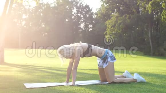 运动的女人在户外做伸展运动健身女孩夏天在公园里做午餐在阳光明媚的日子健身苗条视频的预览图