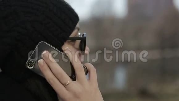 戴太阳镜的年轻女孩通过电话交谈关门视频的预览图
