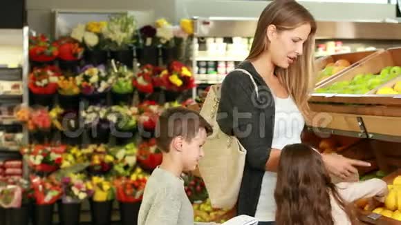 妈妈和孩子们在超市里摘水果视频的预览图