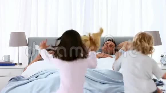 孩子们躺在床上跳上父母视频的预览图