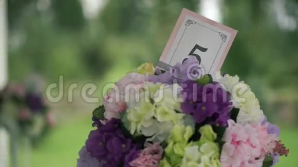 婚礼看台上有编号的桌子黄色白色粉红色和薰衣草花视频的预览图