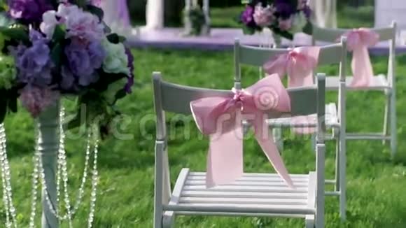 白色的椅子粉红色的蝴蝶结在户外婚礼的维林克结婚装饰品视频的预览图