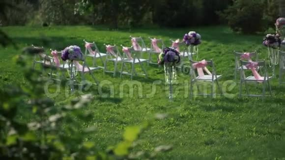 白色的椅子粉红色的蝴蝶结和一个白色和薰衣草颜色的蜡坛视频的预览图