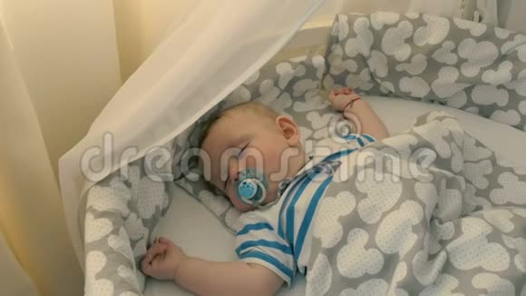 可爱的带假人的小孩睡在婴儿床上视频的预览图