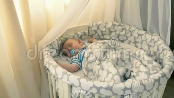 可爱的小男孩在家里睡婴儿床视频的预览图