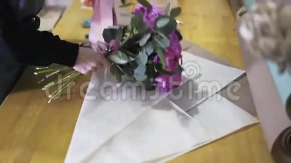 一个女人在商店里包着花束的侧面景色视频的预览图