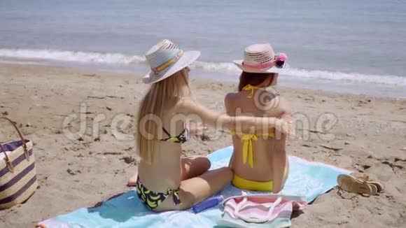 年轻女子在朋友身上涂防晒霜视频的预览图