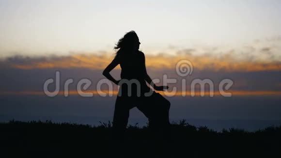 日落后年轻女子剪影跳舞视频的预览图