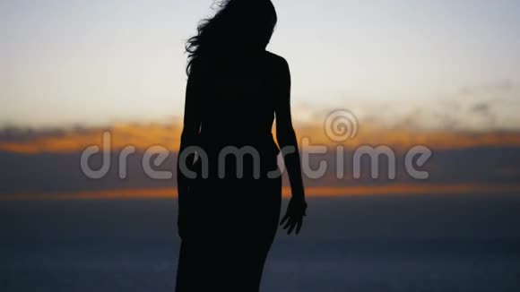 日落后年轻女子剪影跳舞视频的预览图