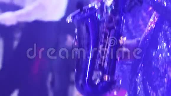 一个带萨克斯管的女孩一个带萨克斯管在舞台上表演的女孩一件蓝色的连衣裙一盏舞台灯一个音乐小组视频的预览图