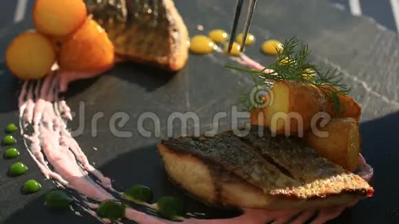 一盘高级菜肴特写镜头小土豆鱼骡子一杯白葡萄酒Primorsik餐厅视频的预览图