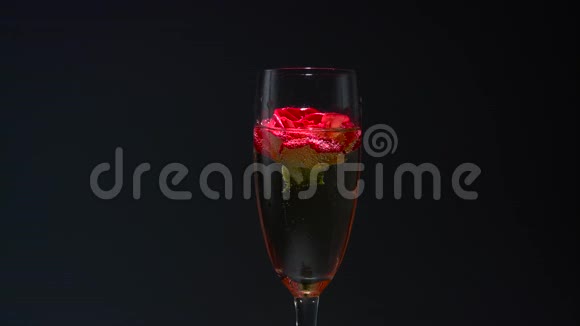杯子底部的玫瑰花蕾侍者往里面倒香槟黑色背景视频的预览图