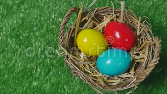 草地上的巢里有五颜六色的复活节彩蛋视频的预览图