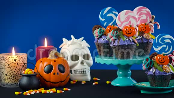 万圣节糖果滴蛋糕风格的纸杯蛋糕与糖果在蓝色背景视频的预览图