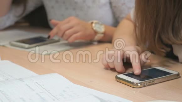 两个不知名的学生女孩带着智能手机视频的预览图