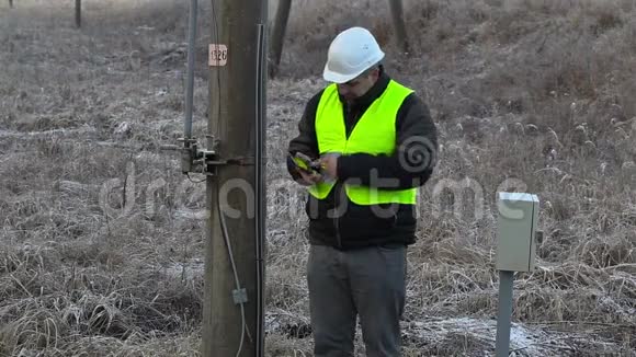 高压电线杆上有智能手机的工人视频的预览图