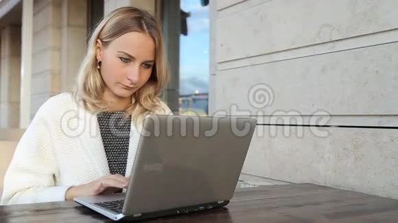 女人在咖啡馆里通过笔记本电脑在线购物视频的预览图