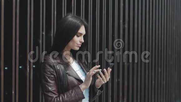 城市里的年轻美女在智能手机上发短信视频的预览图