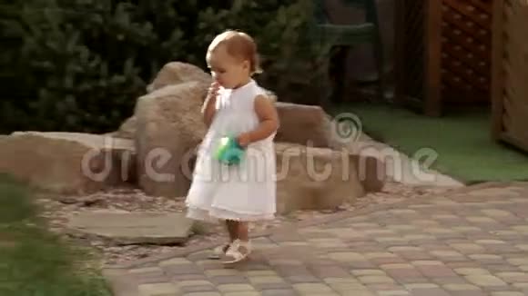 小女孩拿着水桶在操场上散步视频的预览图