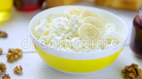 健康的早餐面包屑奶酪和香蕉核桃牛角面包蜂蜜和柠檬果酱在碗里视频的预览图