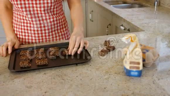 女人把饼干放在烤盘上视频的预览图